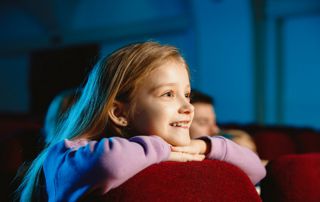 enfant au cinema devant un film