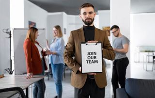 recruteur tenant une affiche "join our team"